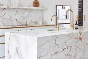 Describe how a marble island can serve as the centerpiece of the kitchen, offering both functional workspace and a striking visual element.